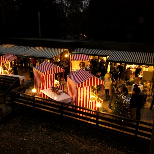 Weihnachtsmarkt mit Buden bei Nacht.