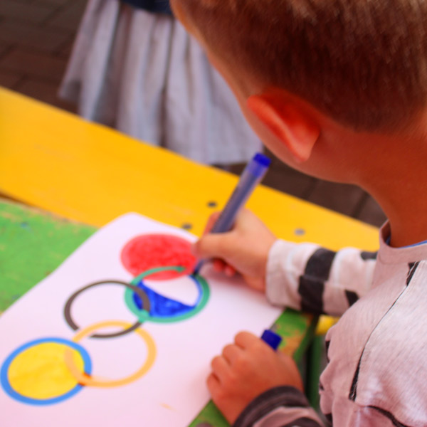Kind malt olympische Ringe.