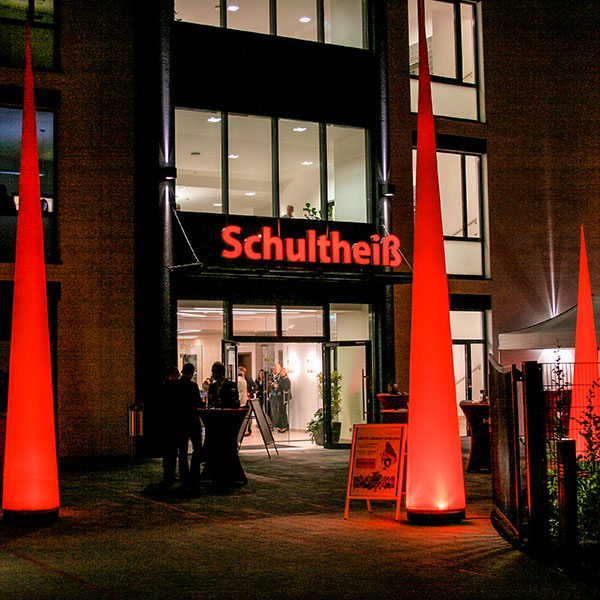 Rote beleuchtete Aircones als Eingangsdekoration vor Firmengebäude