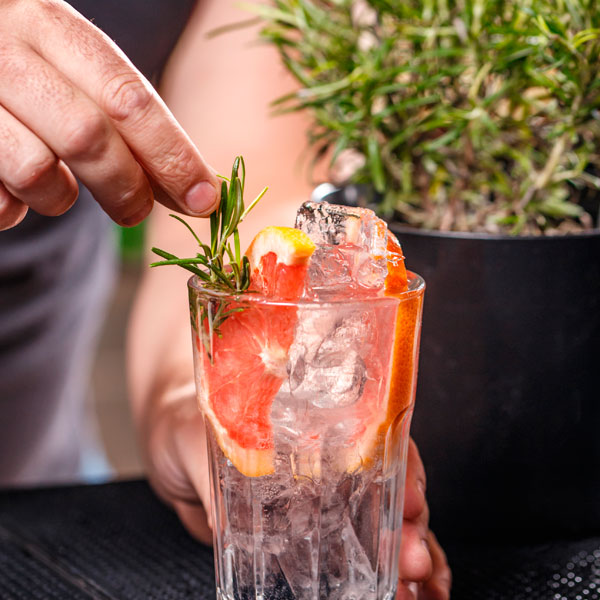 Nahaufname eines edlen Cocktails mit Rosmarin und Grapefruit.