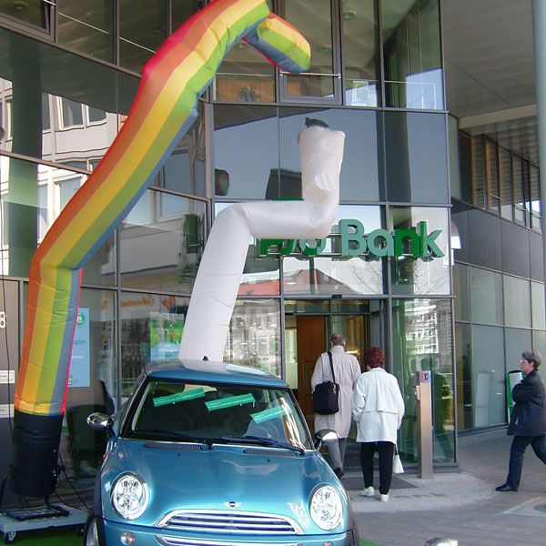 Skydancer in Regenbogen-Farben und in weiß vor Firmengebäude.