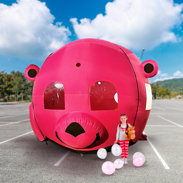 Kind steht mit gefangenen Ballons vor Luftballon Fanganlage im pinken Bärenkopf-Design.