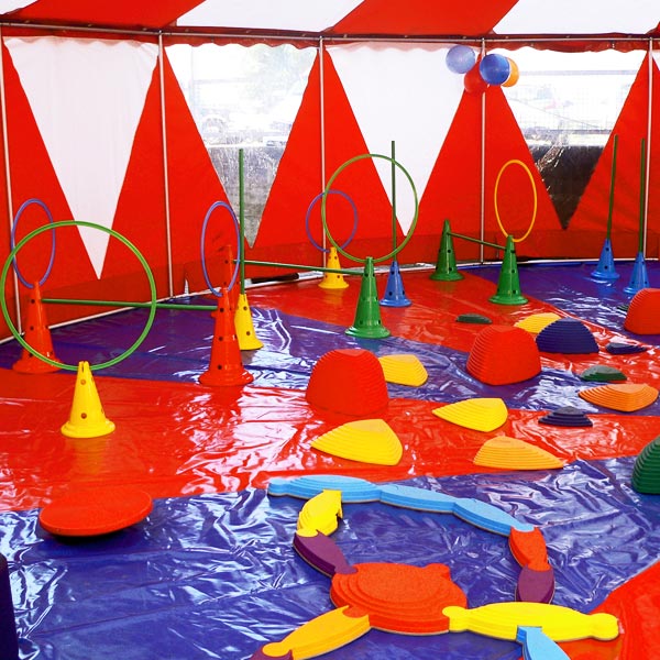 Spiele auf Mangenteppich im rot-weiß gestreiften Zirkuszelt.