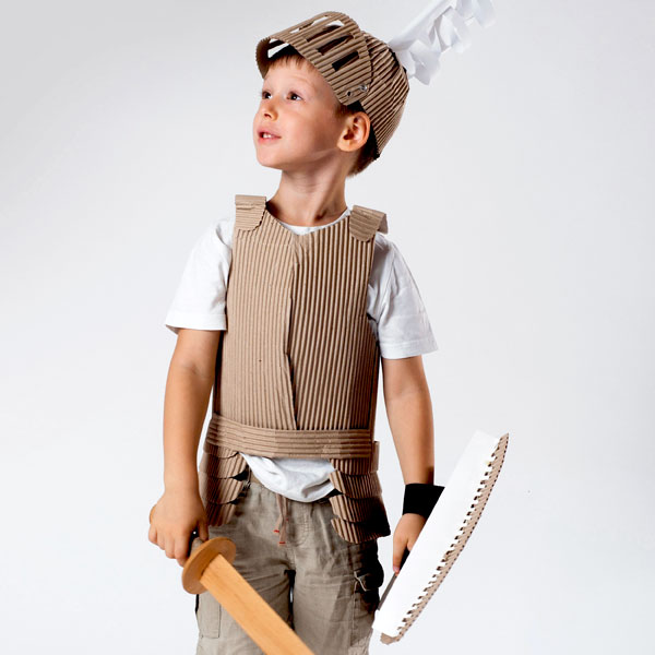 Junge mit Ritterrüstung aus Pappe.