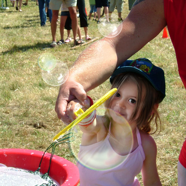 Kind macht Riesen-Seifenblasen.