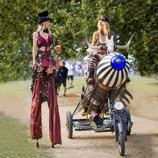 Stelzenläuferin und Steampunk-Rakete.