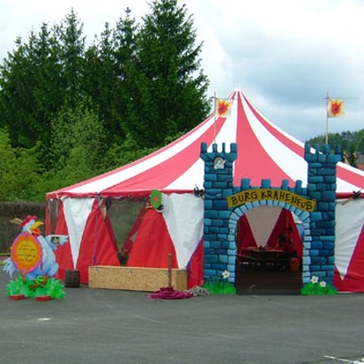 Rot-weiß gestreiftes Zirkuszelt mit Ritterburg-Eingangsportal.