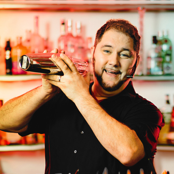 Barkeeper mixt Cocktail im Shaker.