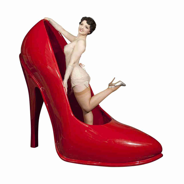Burlesque-Künstlerin steht in rotem Pumps.