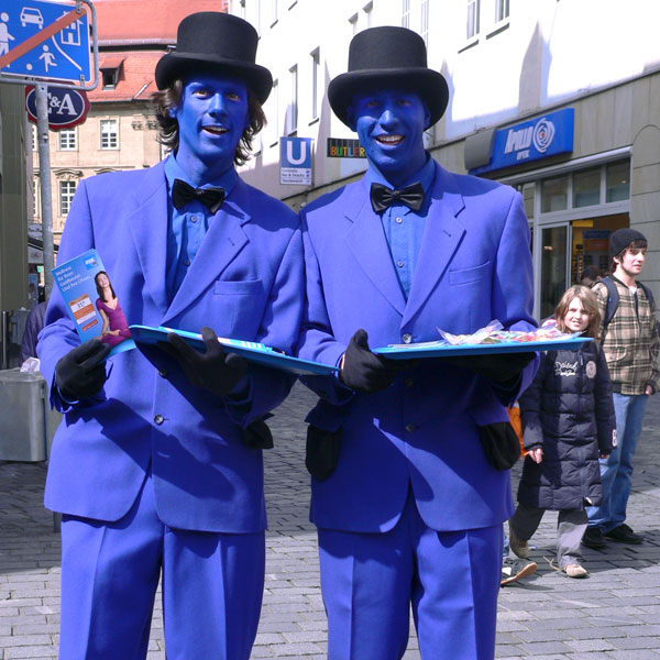 Zwei blaue Colourmen mit Zylinder promoten auf der Straße