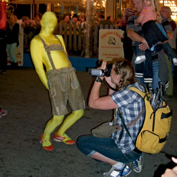 Künstler in gelbem Morphsuit und Lederhose.