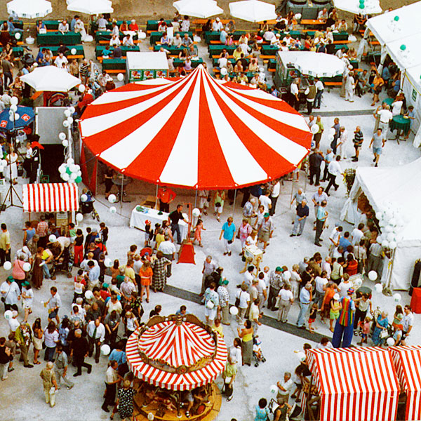 Rot-weißes Zirkuszelt auf einer Großveranstaltung, Zusammen mit Marktbuden.