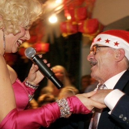 Marilyn Monroe Double besingt Mann mit Weihnachtsmütze.
