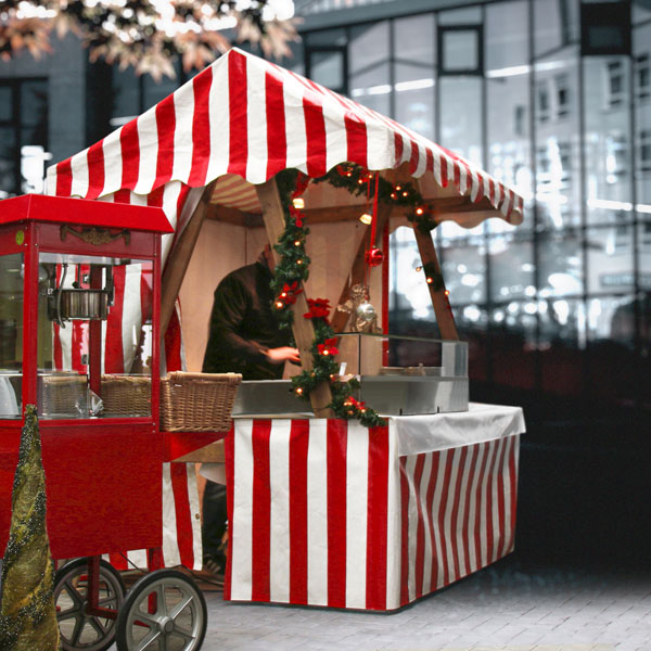 Weihnachtsmann-Marktstand mit Popcornwagen.