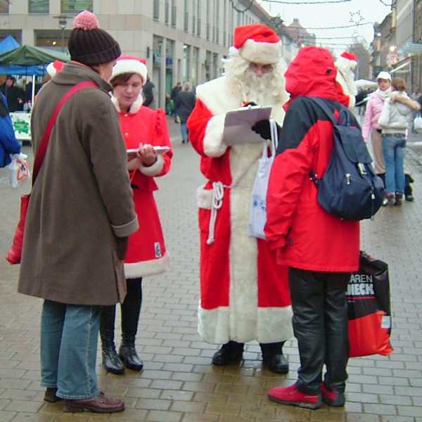 Weihnachtsmann und Weihnachtsfrau mit Passanten.