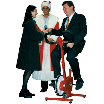 Weihnachtsmann und Animateurin bei Gast auf Trimm-dich-Fahrrad.