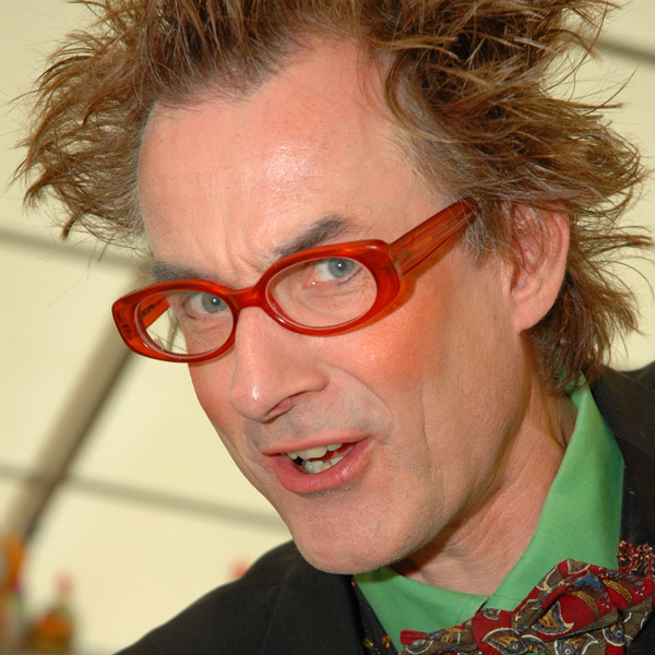 Gesicht eines Entertainers mit roter Brille und Fliege.