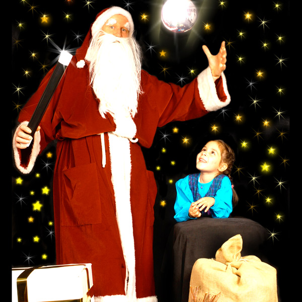Zaubernder Weihnachtsmann führt staunendem Kind Zaubertricks vor.