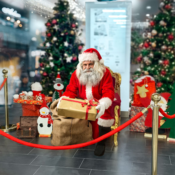 Nikolaus im Weihnachtsmann-Kostüm im Einkaufscenter/Supermarkt